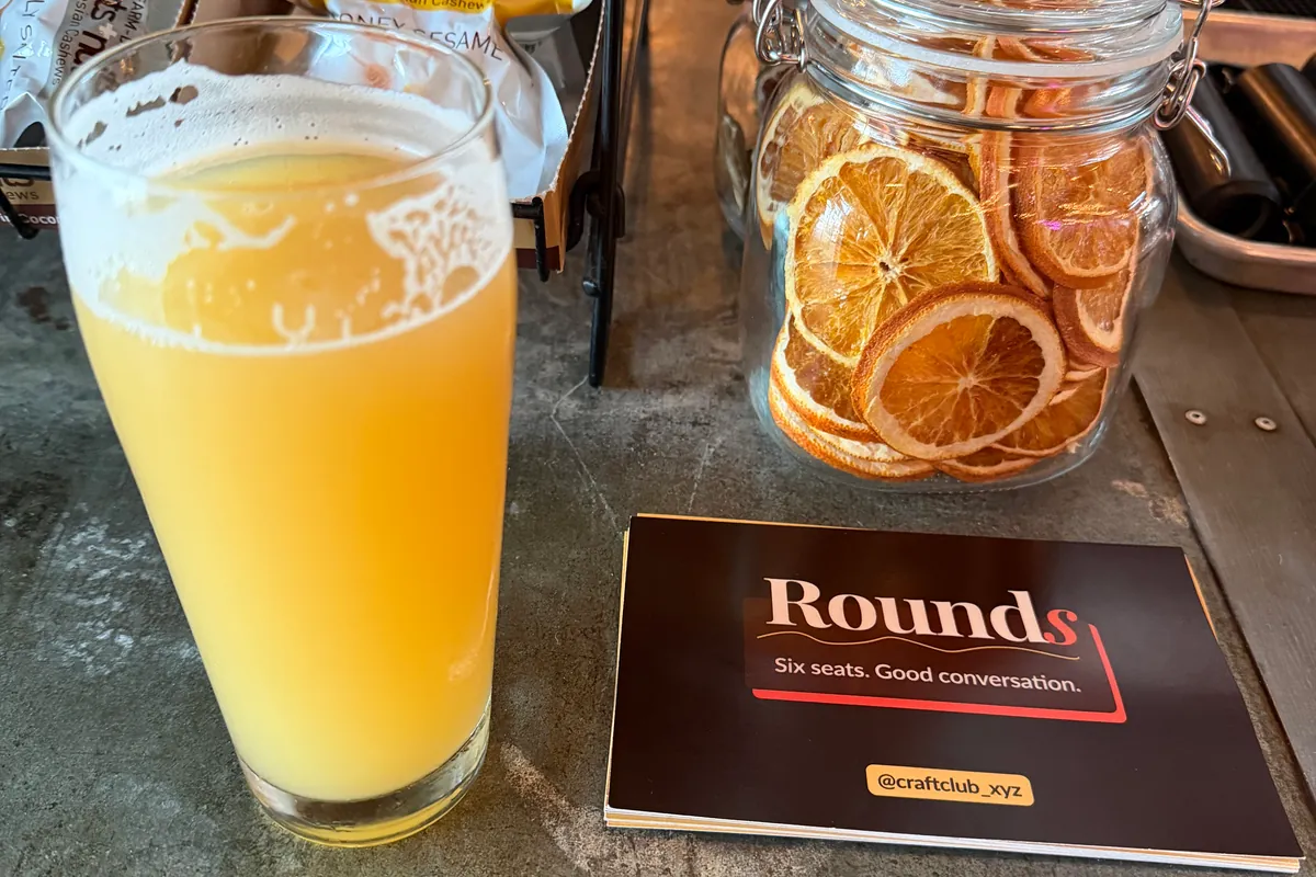 A Rounds card and a hazy beer on the bar at an NYC brewery