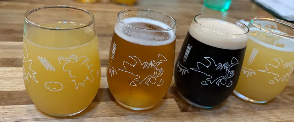 Four beer tasters lined up light to dark on a Rounds table